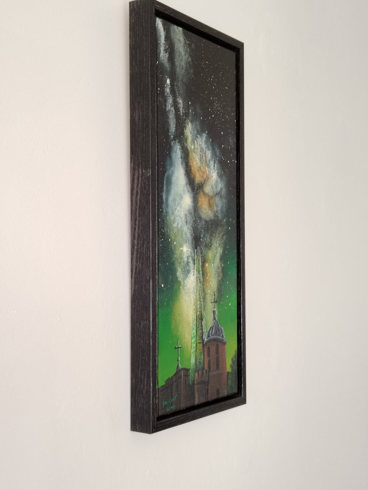 Side view of the acrylic painting of the Milkyway rising above the Shard and The Tower of London hung on a white wall.