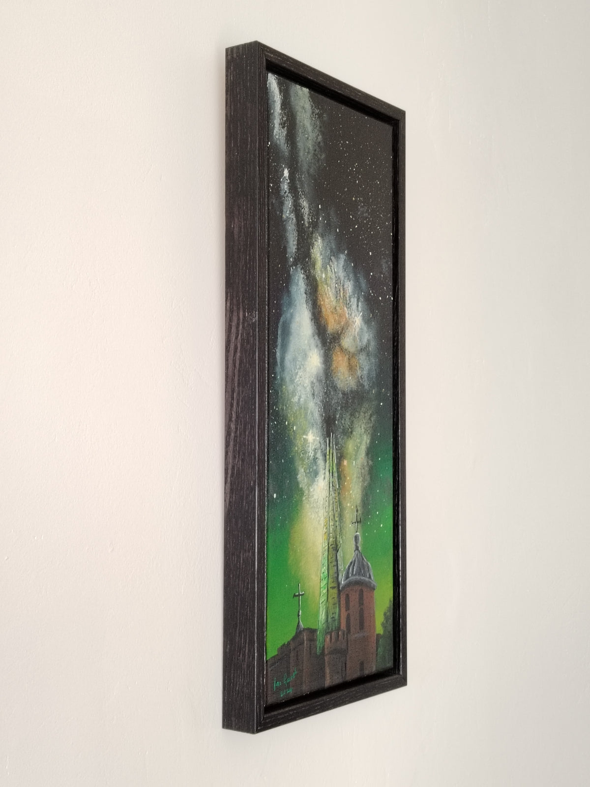 Side view of the acrylic painting of the Milkyway rising above the Shard and The Tower of London hung on a white wall.