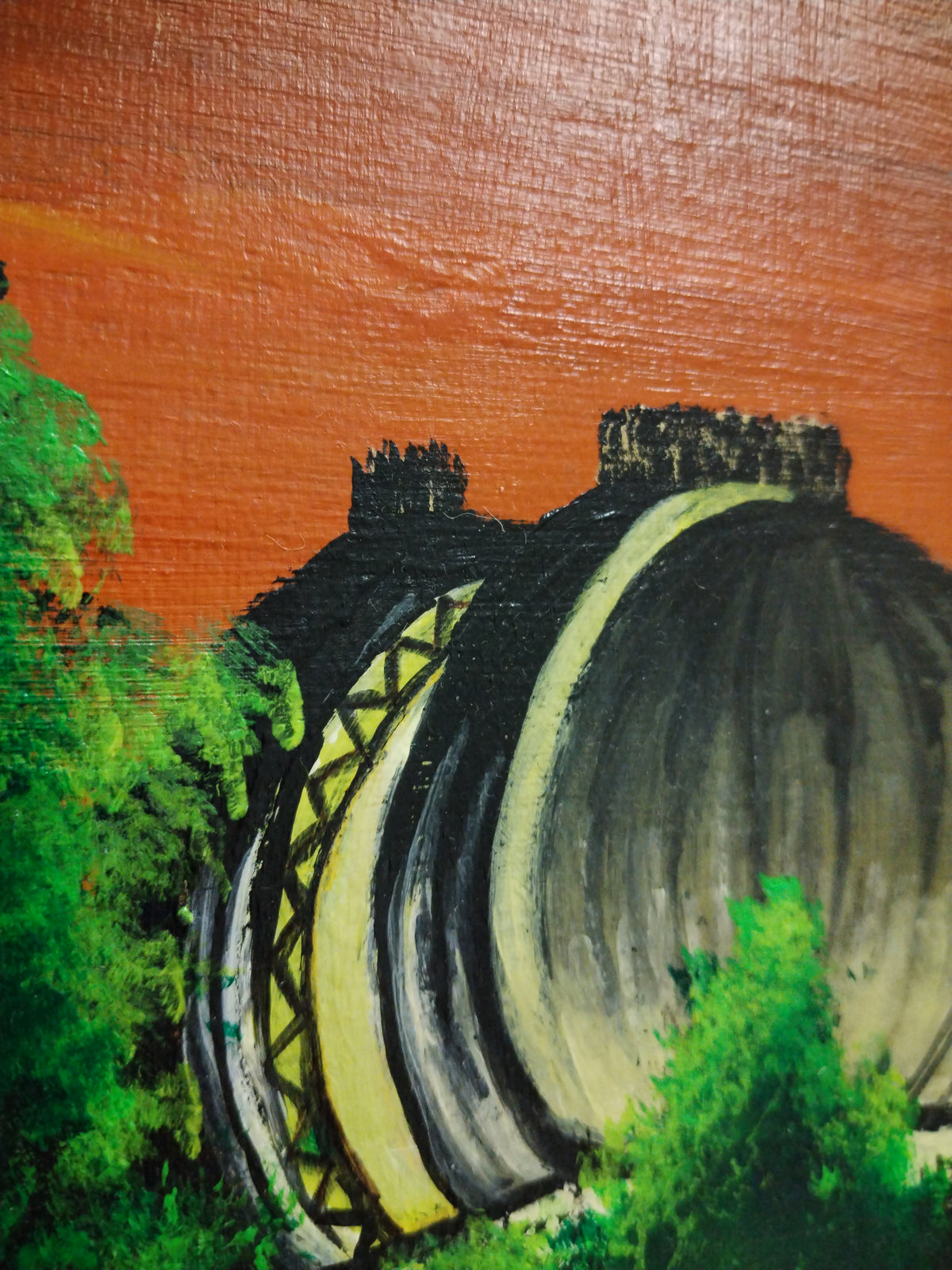 Close-up of a painting featuring the Greenwich Observatory against an orange sky, showcasing details of the structure.