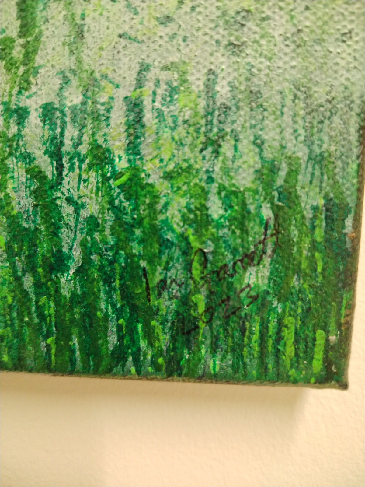 Close-up of the signature on the Stonehenge Fog painting by Ian Garrett, showcasing textured green brush strokes.